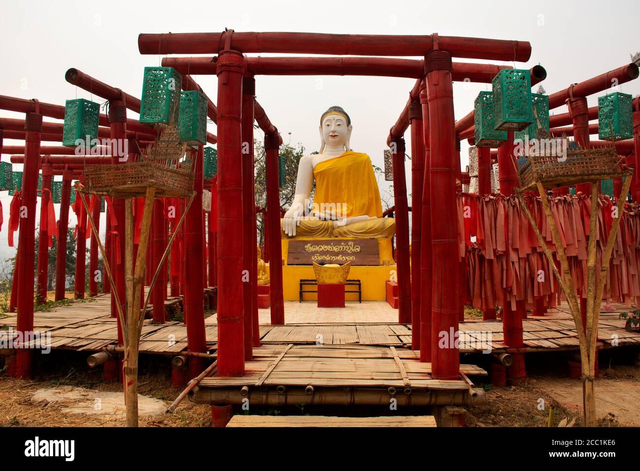 Grande statua del buddha e Torii rosso in Wat Phu SA Ma tempio con su Tong Pae ponte per la gente tailandese E i viaggiatori stranieri visitano la città di Pai in preghiera Foto Stock