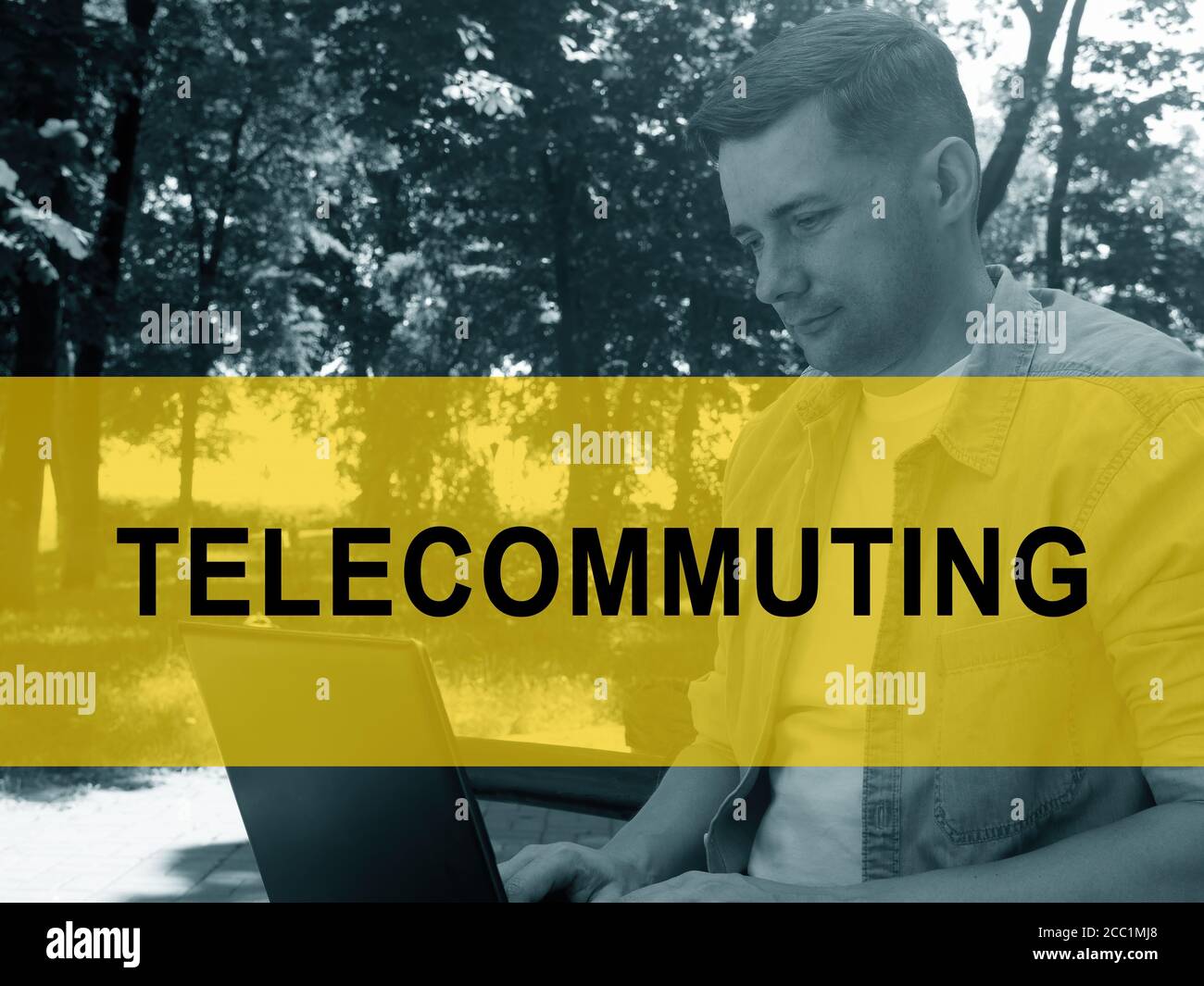 Concetto di telelavoro. Un giovane sta scrivendo su un computer portatile nel parco. Foto Stock