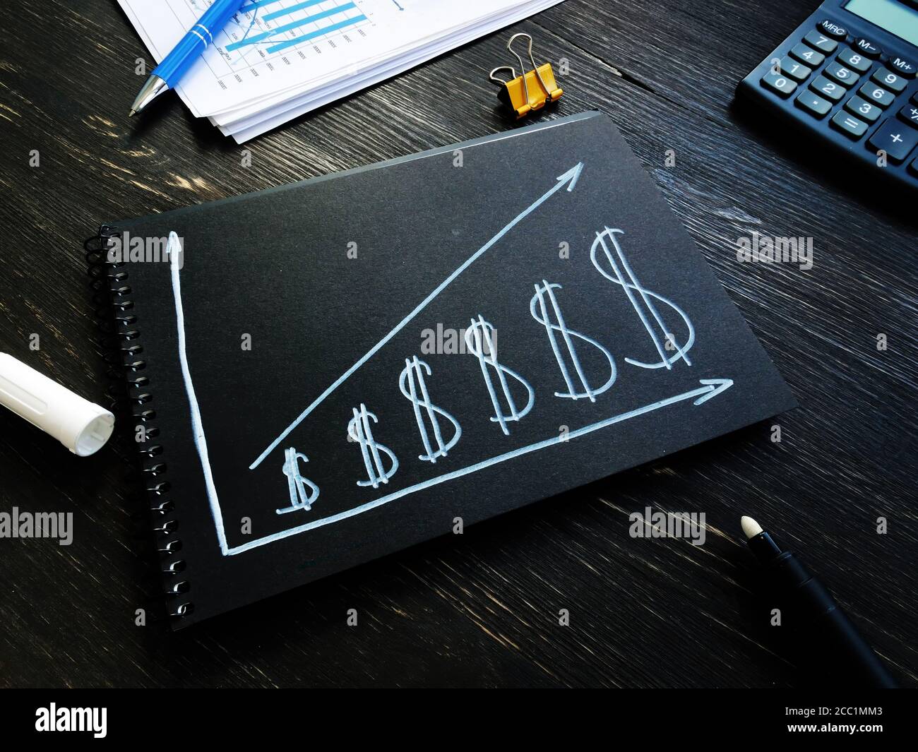 Aumentare il concetto di fatturato e profitto. Segni del dollaro e freccia crescente. Foto Stock