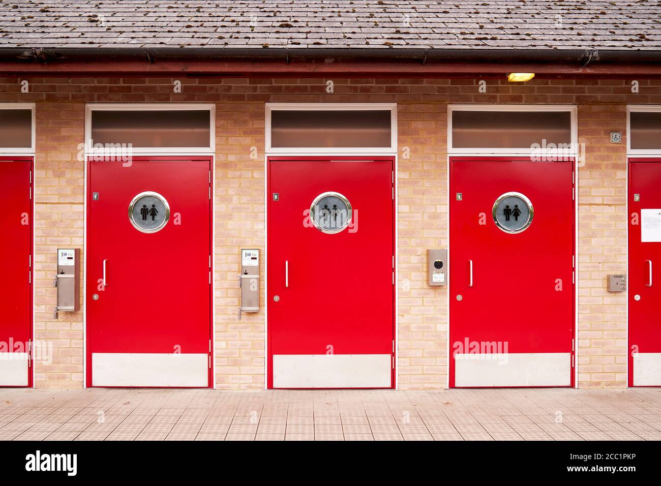 Porte per wc pubbliche unisex di colore rosso brillante Foto Stock