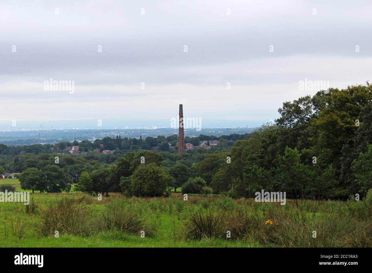 Paesaggi mozzafiato di NW England inc Wigan e Bolton in una giornata nuvolosa con Barrow Bridge Chimney in vista da Winter Hill, Bolton Foto Stock