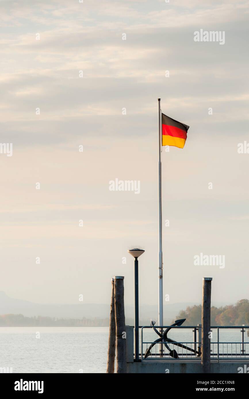 Germania, Allensbach, vista della bandiera tedesca sul molo e il Lago di Costanza Foto Stock