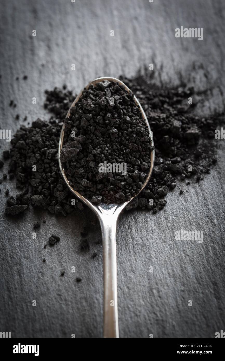 Cucchiaio riempito con sale nero, primo piano Foto Stock