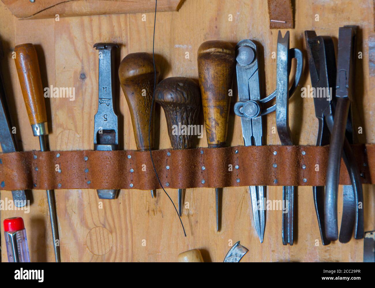 Fatte a mano in pelle strumento artigianale sul backgrounde in legno Foto Stock