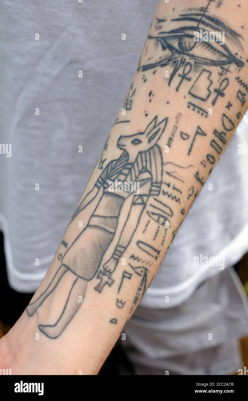 tatuaggi di stile egiziano su braccio maschio giovane Foto Stock