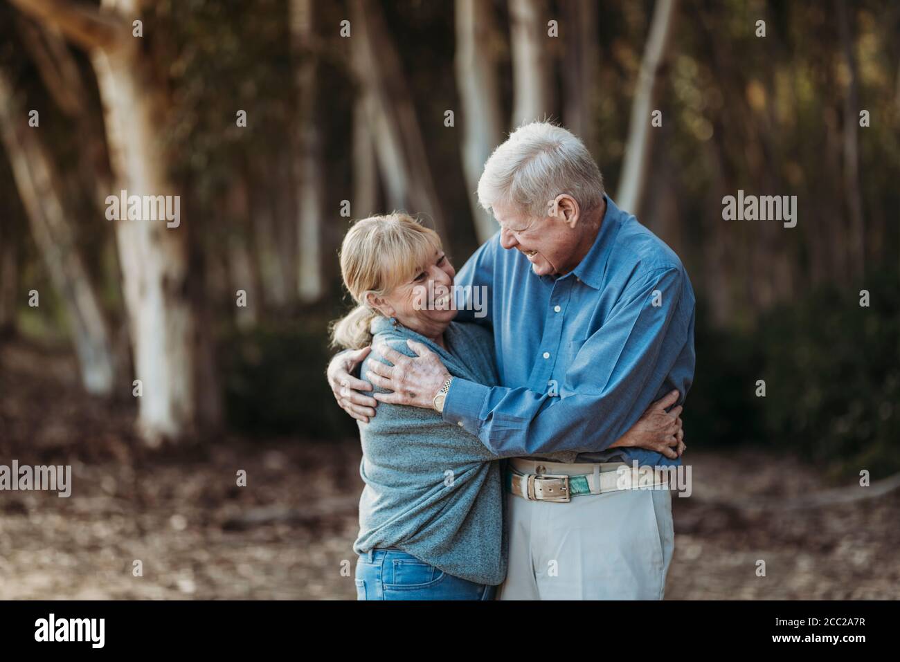 Ritratto di coppia adulta anziana abbracciata nella foresta Foto Stock