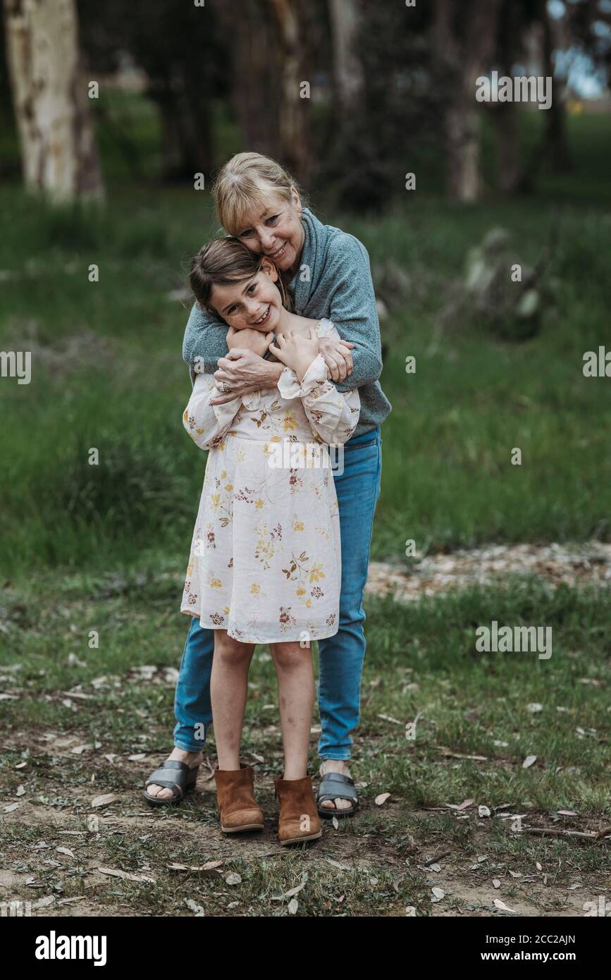 Nonna e nipote abbracciano e sorridono sul campo Foto Stock