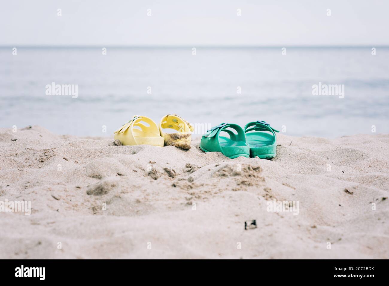 due paia di sandali su una spiaggia di sabbia in estate Foto Stock