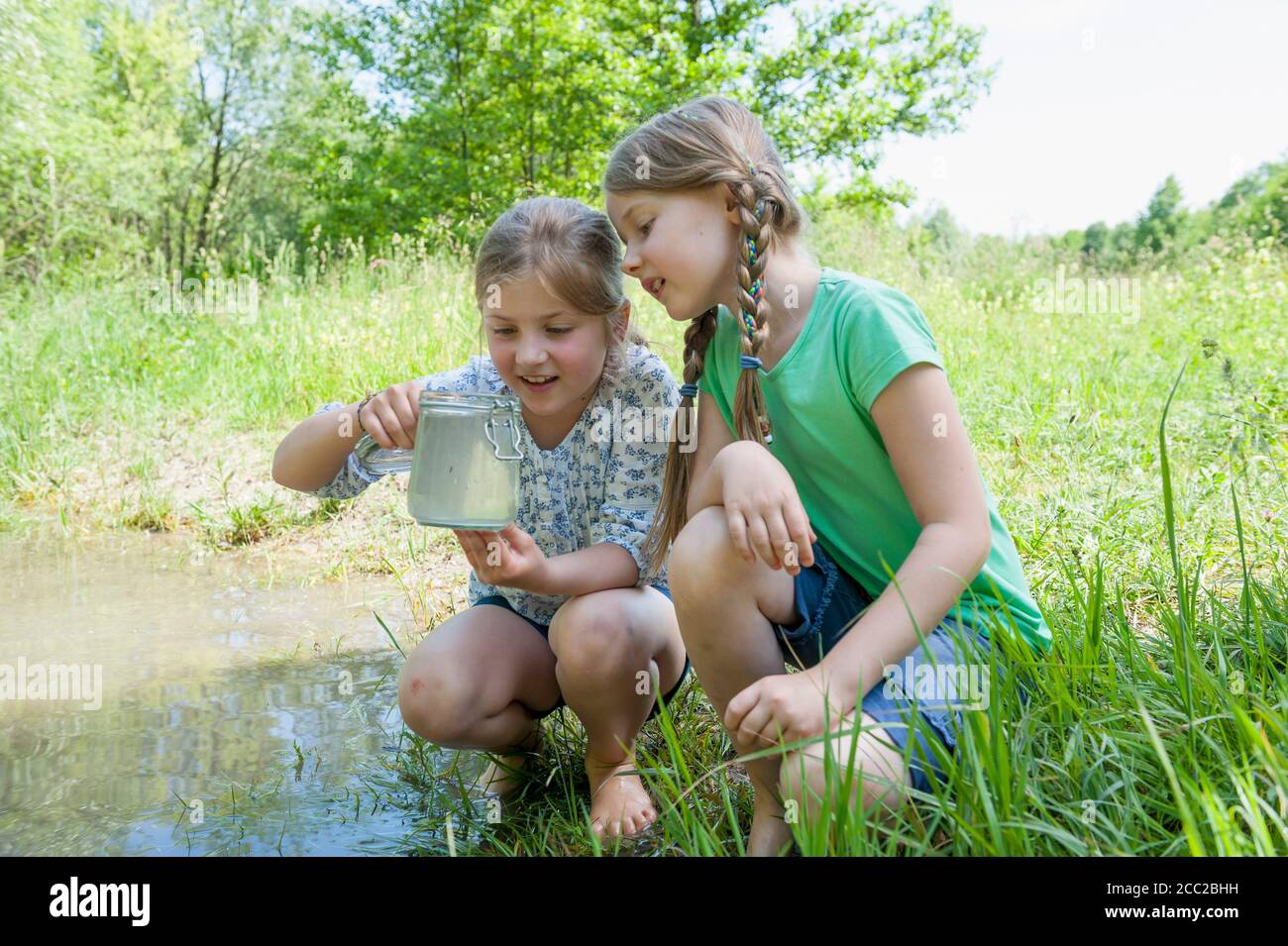 In Germania, in Baviera, Monaco di Baviera, le ragazze a giocare a lato lago Foto Stock