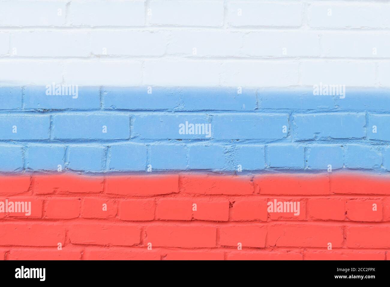 Un muro dipinto in mattoni nei colori della bandiera della Russia. Foto Stock