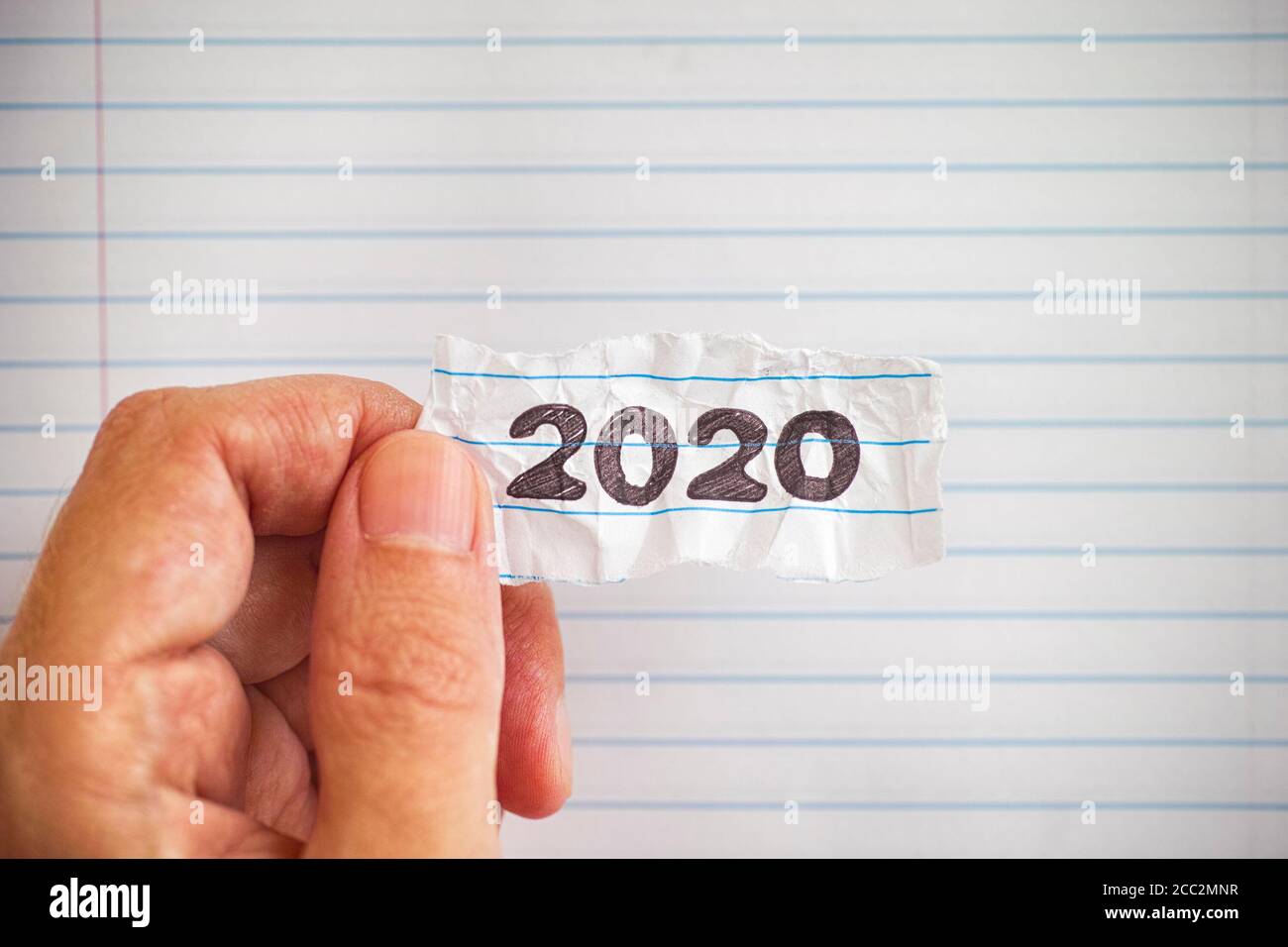 Persona che tiene un pisello di carta con l'anno 2020 su esso. Primo piano. Foto Stock