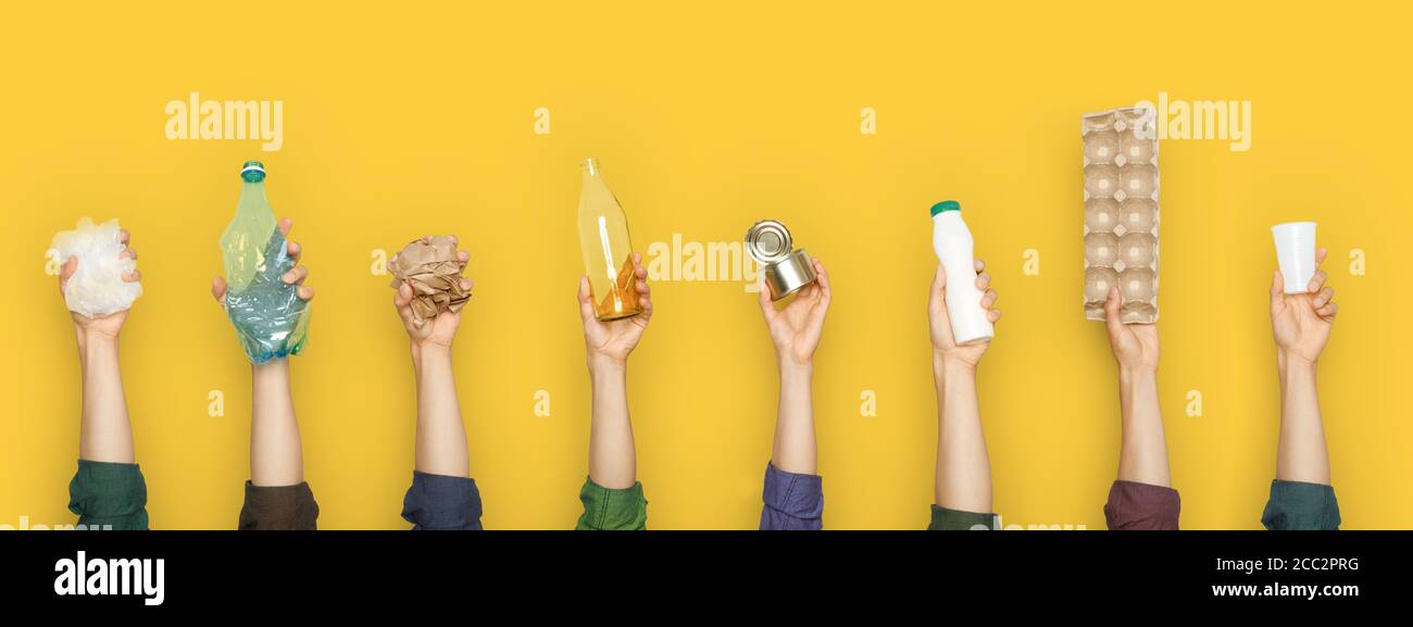 Vista parziale del gruppo di persone che detengono vari tipi di immondizia su sfondo giallo Foto Stock