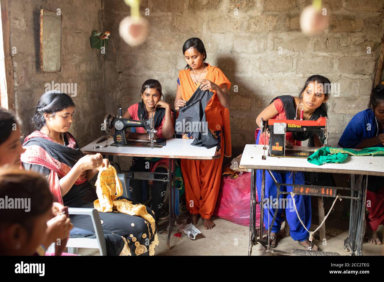 Le giovani donne lavorano insieme in un negozio di sartoria a Susta, Nepal, Asia meridionale. Foto Stock
