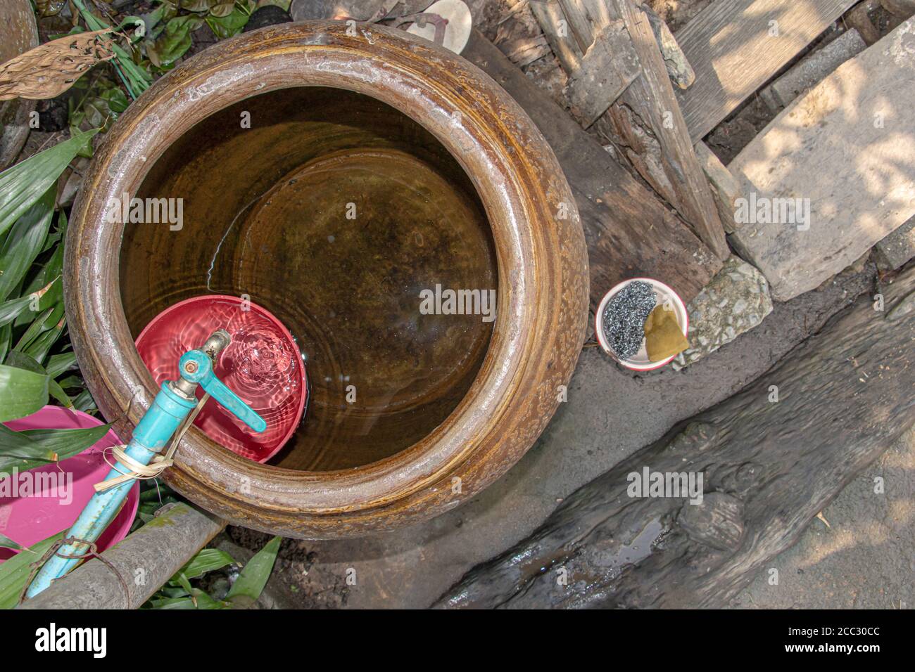 La canna in ceramica con acqua per uso domestico in campagna tailandese. Bagno all'aperto in cortile di casa in Asia. Foto Stock