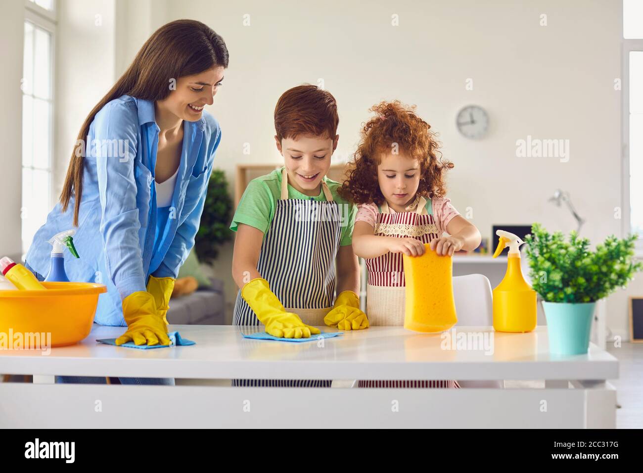 Camera per la pulizia della famiglia insieme e divertirsi. I capretti che aiutano il genitore a fare i chores domestici a casa Foto Stock