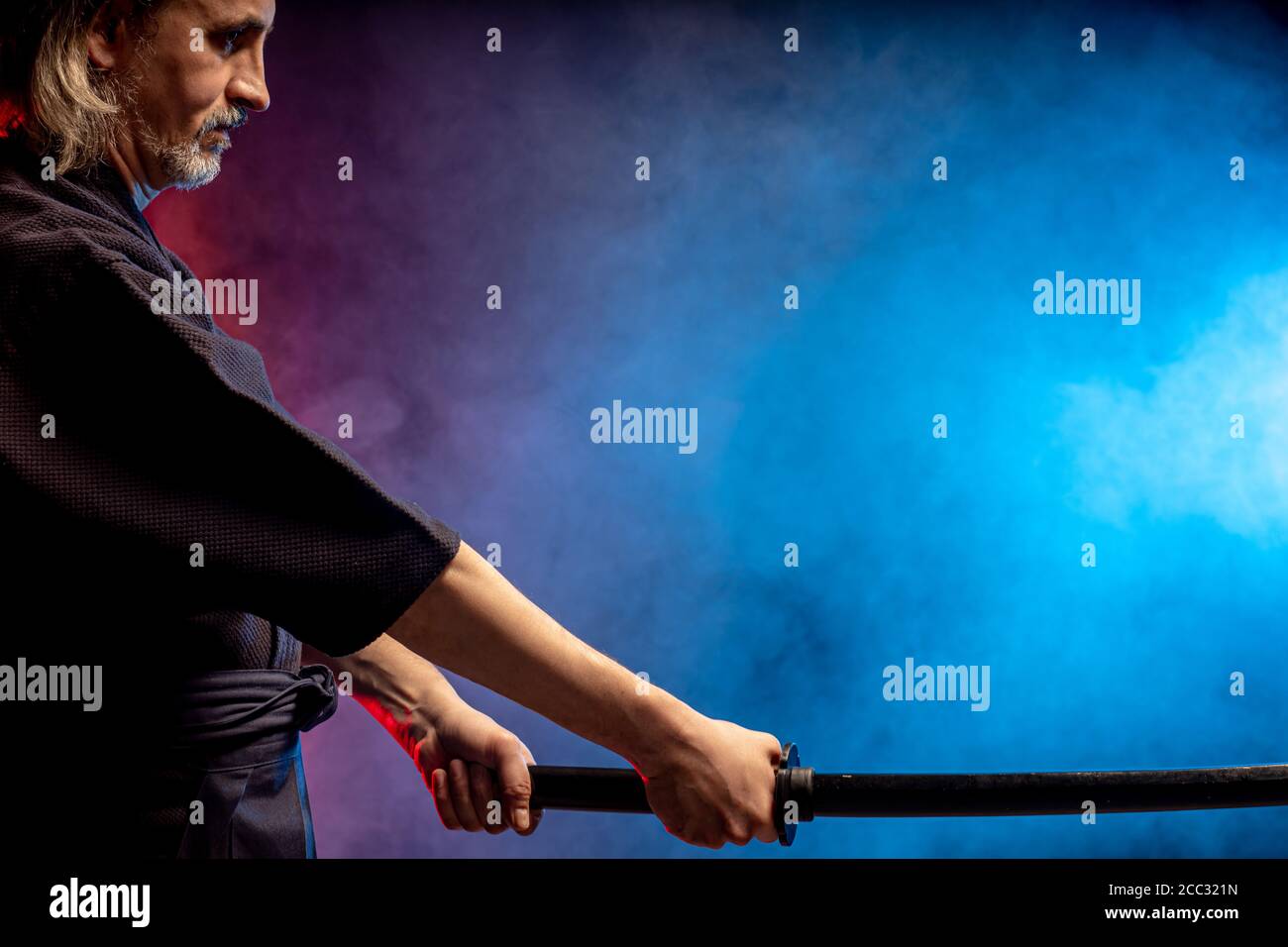 combattente caucasico maturo in abito con spada di bambù shinai , pratica lotta prima delle competizioni. arte marziale giapponese tradizionale concetto. isol Foto Stock