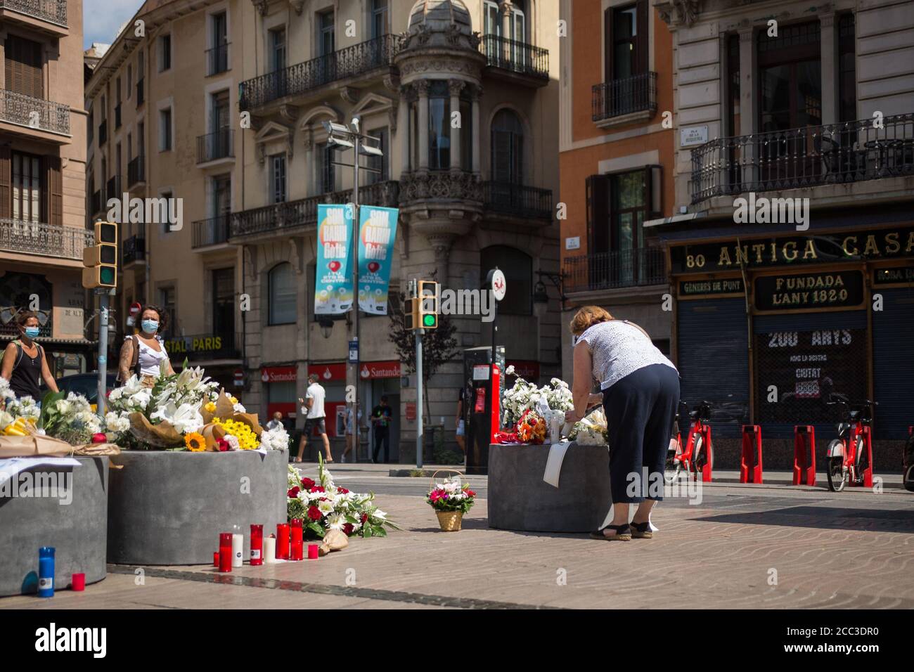 Una donna rende omaggio alle vittime dell'attacco di Barcellona.tre anni dopo l'attacco a Barcellona, un tributo alle vittime è fatto a Las Ramblas. Foto Stock