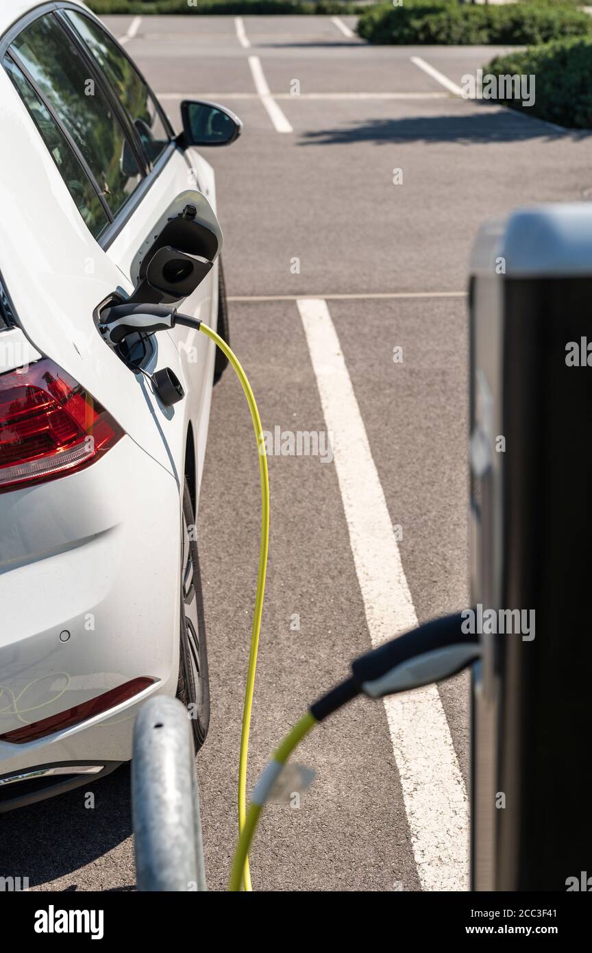 Un'auto elettrica presso la stazione di ricarica Foto Stock