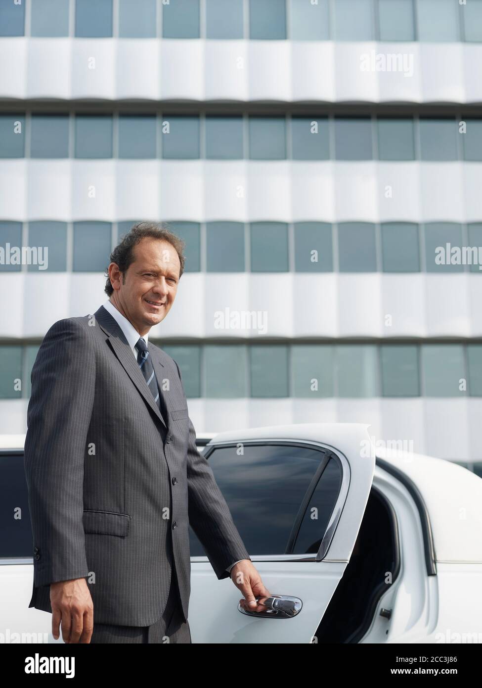 Ritratto di uomo che lavora come conducente in limousine bianca Foto Stock