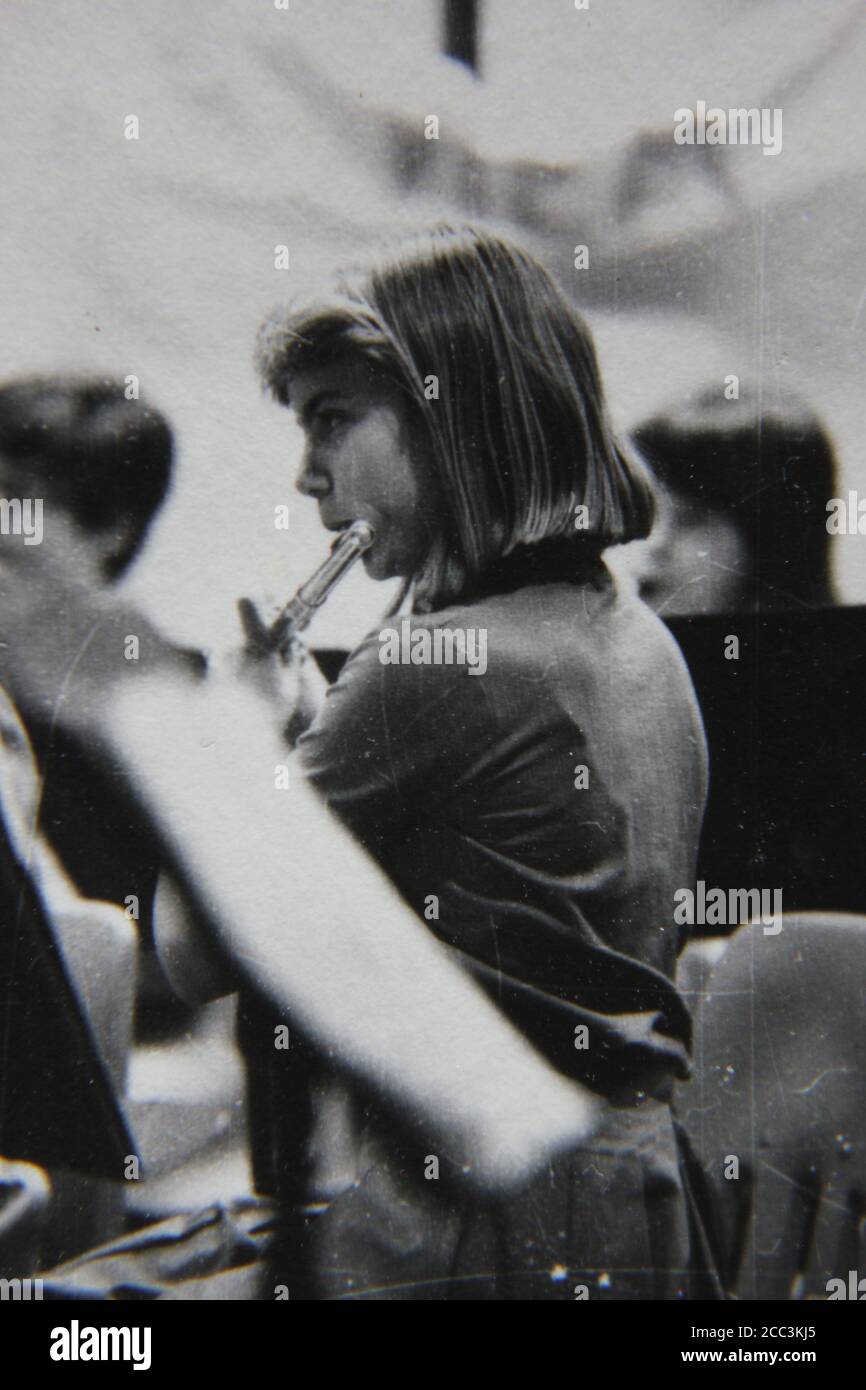 Bella fotografia in bianco e nero degli anni '70 di un giovane flauto che suona il flauto in un recital scolastico. Foto Stock