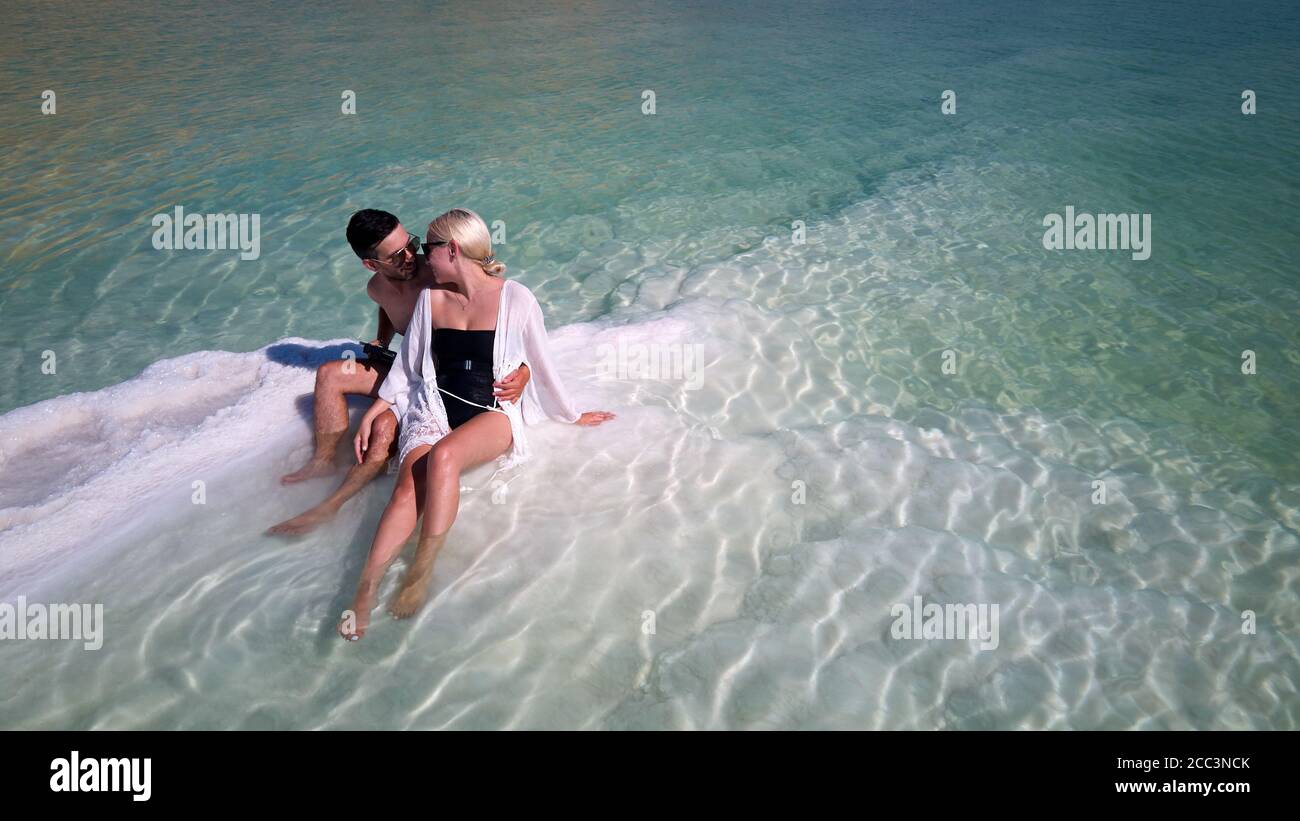 Immagine aerea di bellissimi modelli coppia appassionata baciando e abbracciando in acqua di mare. Mare morto Israele Foto Stock