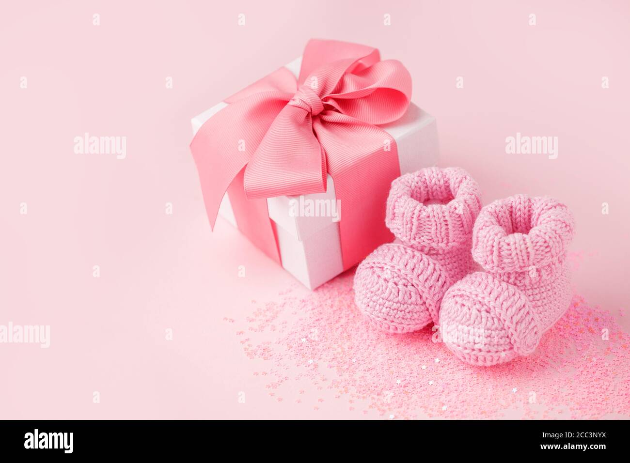 Primo piano di scarpe per bambini, regalo in confezione - dolcezza e baby  stoeties su sfondo rosa, primo neonato party di fondo, compleanno, regalo  regalo givin Foto stock - Alamy