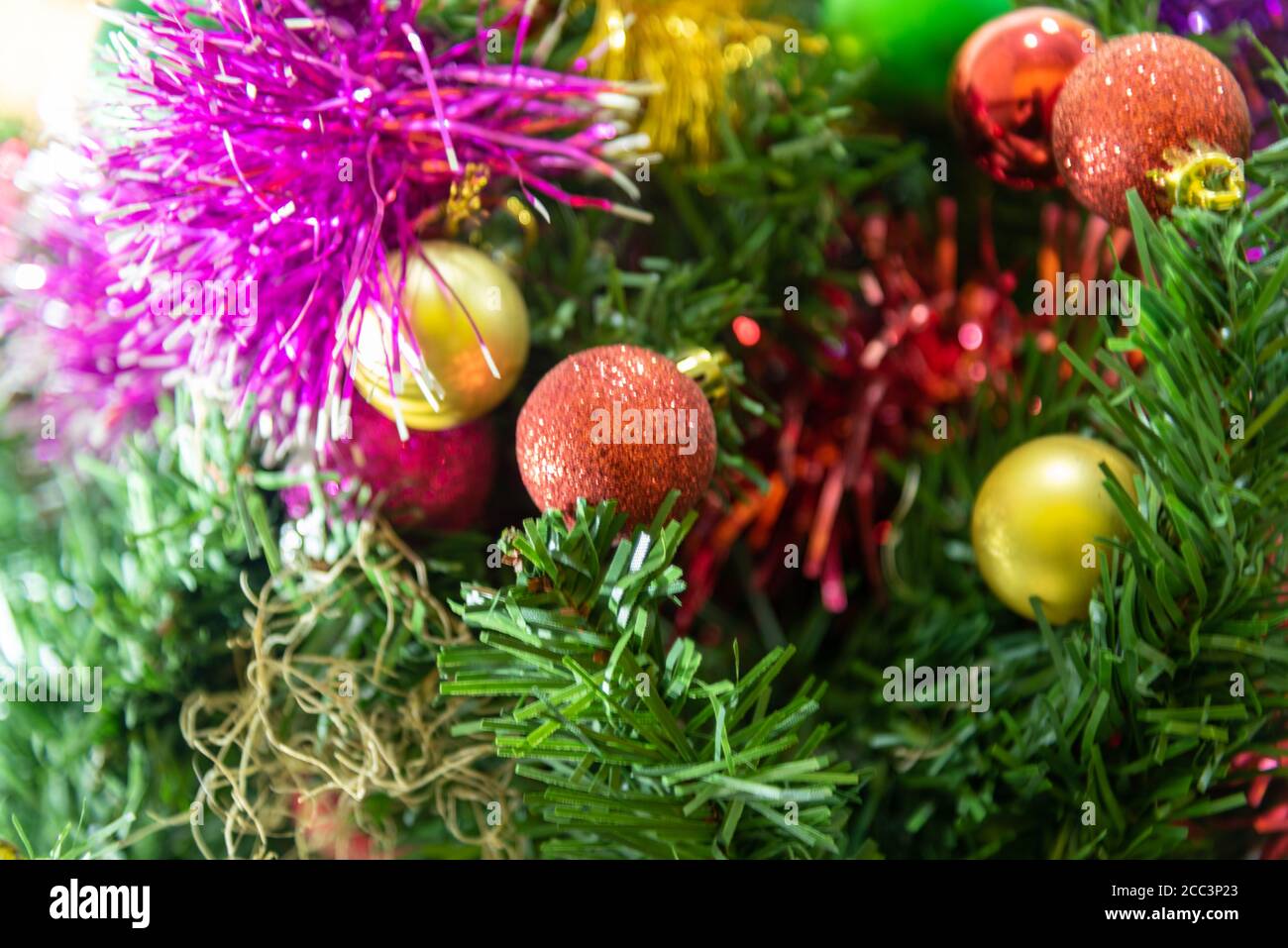 Decorazione di Natale. Immagine di un albero di Natale con alcune palline colorate e ornamenti con motivi per la celebrazione del giorno di Natale. Cristiano f Foto Stock