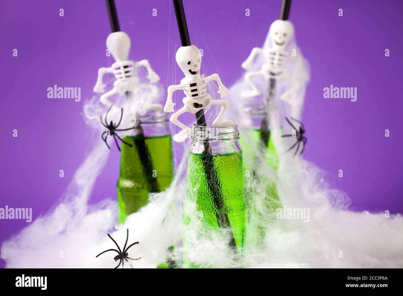 Carino Halloween verde bevande per una festa dei bambini in spider cobweb su sfondo viola tradizionale, cibo divertente per la vacanza di autunno stagionale, menu, volantino, io Foto Stock