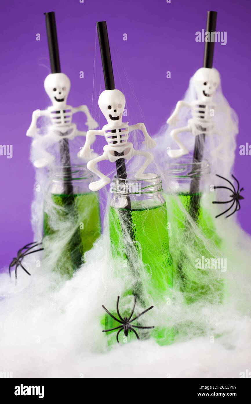 Carino Halloween verde bevande per una festa dei bambini in spider cobweb su sfondo viola tradizionale, cibo divertente per la vacanza di autunno stagionale, menu, volantino, io Foto Stock