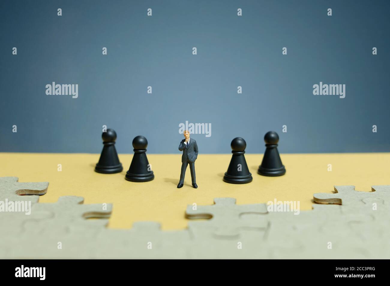 Foto concettuale strategia aziendale - miniatura di uomo d'affari in piedi il mezzo sulla linea dell'esercito degli scacchi con puzzle Foto Stock