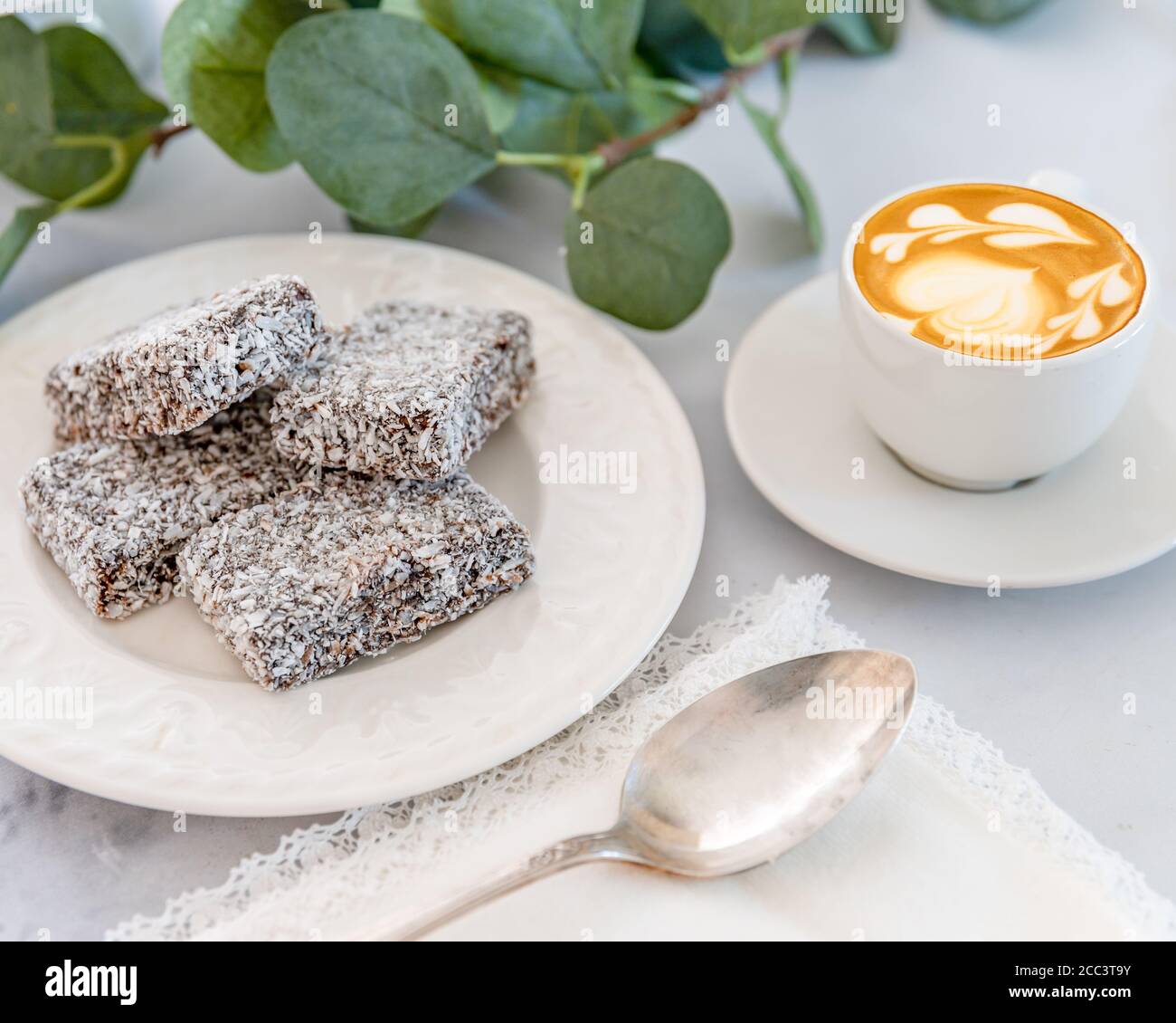 Torta di Lamington con foglie di pianta di caffè e cucchiaio Foto Stock