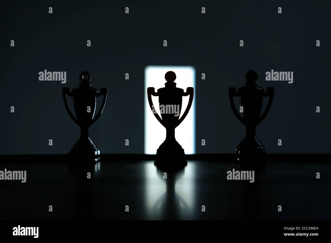 Foto concettuale della strategia aziendale – Silhouette dello stand trofeo al centro del tavolo da ufficio Foto Stock