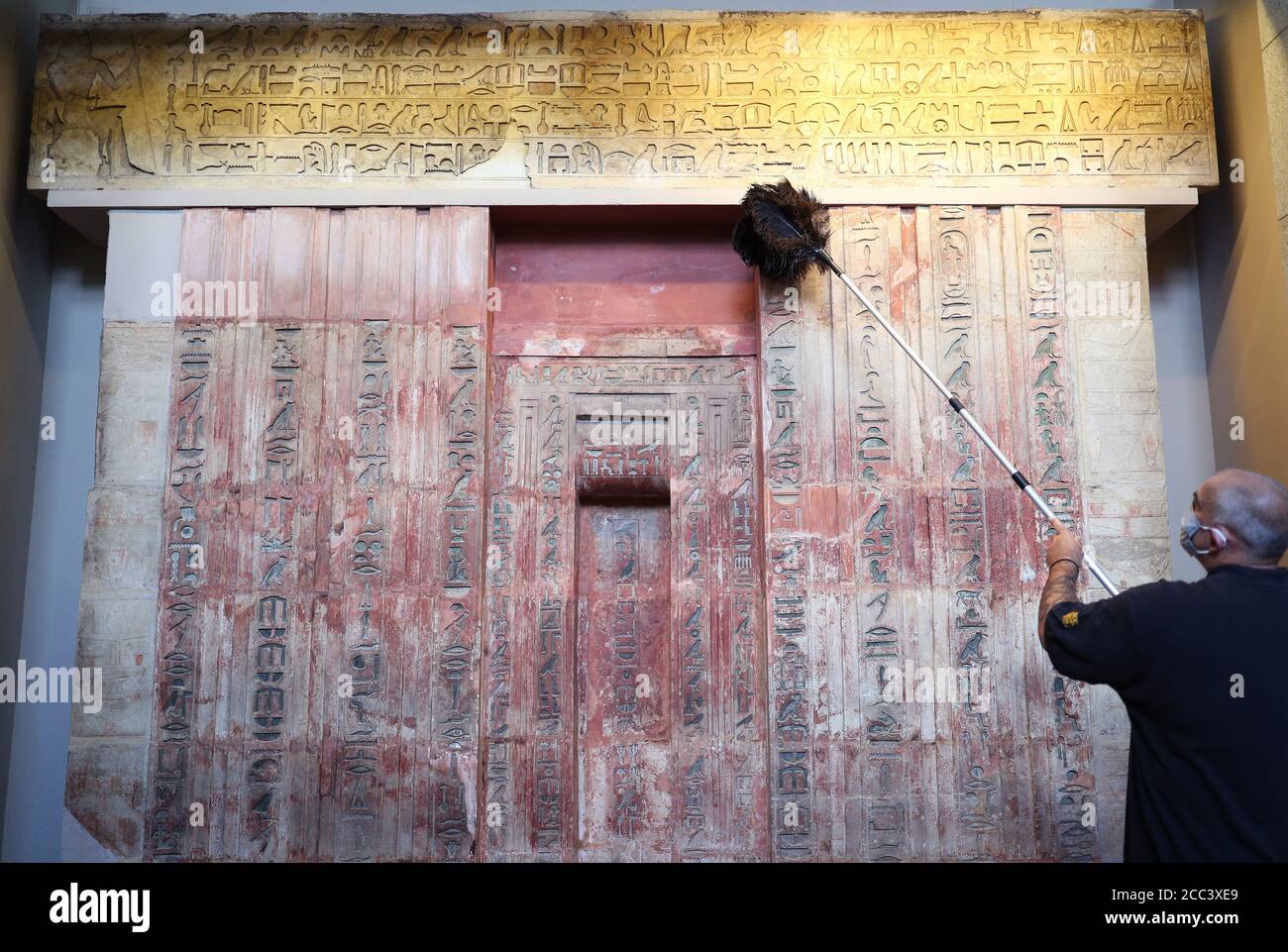 Il manager della collezione Evan York spolverò la falsa porta e l'architrave di Ptahshepses (circa 2400 a.C.), nella Egyptian Sculpture Gallery al British Museum di Londra, mentre si preparano a riaprire al pubblico il 27 agosto dopo il blocco del coronavirus. Prima della riapertura, il British Museum ha avviato il più grande programma di pulizia individuale degli ultimi decenni. Foto Stock
