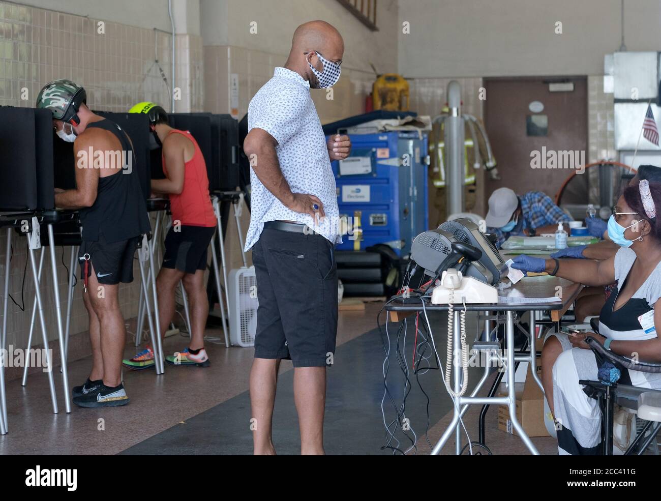 Miami, Stati Uniti. 18 agosto 2020. I residenti di Miami in Florida si accingono al banco di registrazione e hanno fatto il loro voto il giorno delle elezioni primarie per i candidati alla stazione Miami Fire and Rescue 2 di Miami, Florida, martedì 18 agosto 2020. Le linee dei siti di polling sono più brevi e in alcuni casi inesistenti a causa del COVID-19, Coronavirus Pandemic. Foto di Gary i Rothstein/UPI Credit: UPI/Alamy Live News Foto Stock
