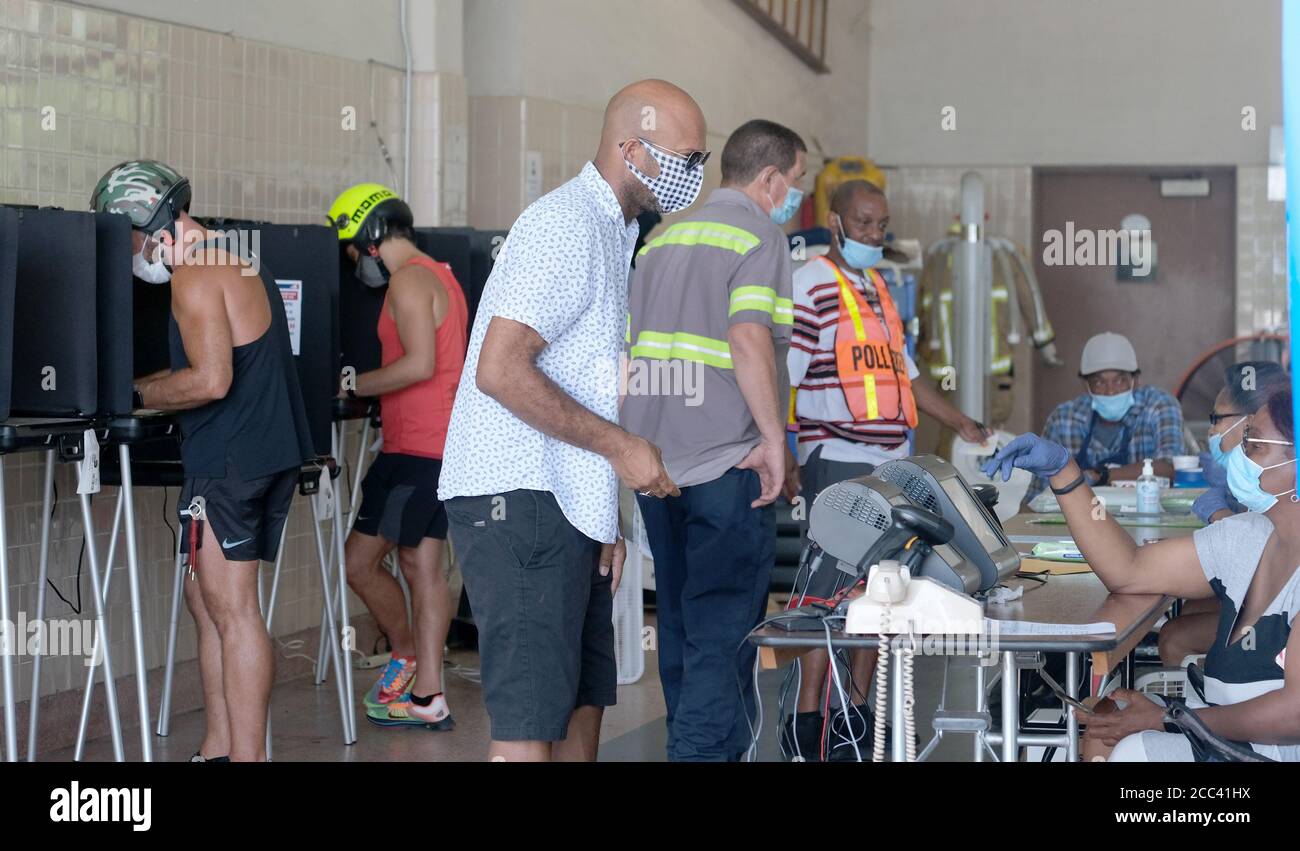 Miami, Stati Uniti. 18 agosto 2020. I residenti di Miami in Florida si accingono al banco di registrazione e hanno fatto il loro voto il giorno delle elezioni primarie per i candidati alla stazione Miami Fire and Rescue 2 di Miami, Florida, martedì 18 agosto 2020. Le linee dei siti di polling sono più brevi e in alcuni casi inesistenti a causa del COVID-19, Coronavirus Pandemic. Foto di Gary i Rothstein/UPI Credit: UPI/Alamy Live News Foto Stock
