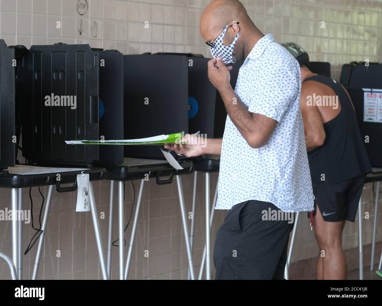 Miami, Stati Uniti. 18 agosto 2020. I residenti di Miami in Florida si accingono al banco di registrazione e hanno fatto il loro voto il giorno delle elezioni primarie per i candidati alla stazione Miami Fire and Rescue 2 di Miami, Florida, martedì 18 agosto 2020. Le linee dei siti di polling sono più brevi e in alcuni casi inesistenti a causa del COVID-19, Coronavirus Pandemic. Foto di Gary i Rothstein/UPI Credit: UPI/Alamy Live News Foto Stock