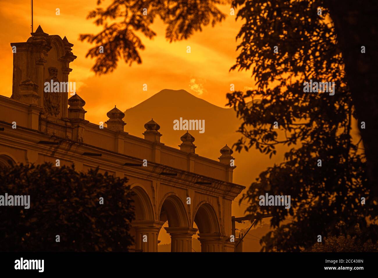 Palazzo Generale del Capitano / Palacio de los Capitanes Generales nella città Antigua Guatemala e Volcán de Fuego al tramonto, Sacatepéquez, Guatemala Foto Stock