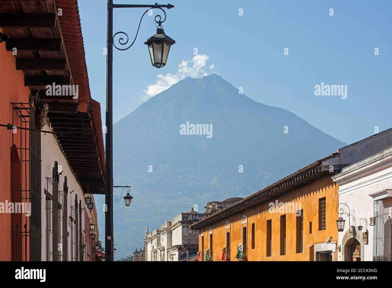 Volcán de Fuego vulcani e colorate case coloniali nella città Antigua Guatemala, Dipartimento Sacatepéquez, Guatemala, America Centrale Foto Stock