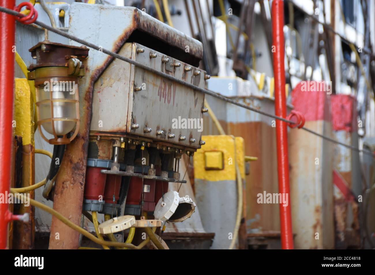 Scatola elettrica grigia per il collegamento delle spine rosse dai contenitori a reefer alle prese all'interno della scatola per erogare corrente per il raffreddamento del carico deperibile. Foto Stock