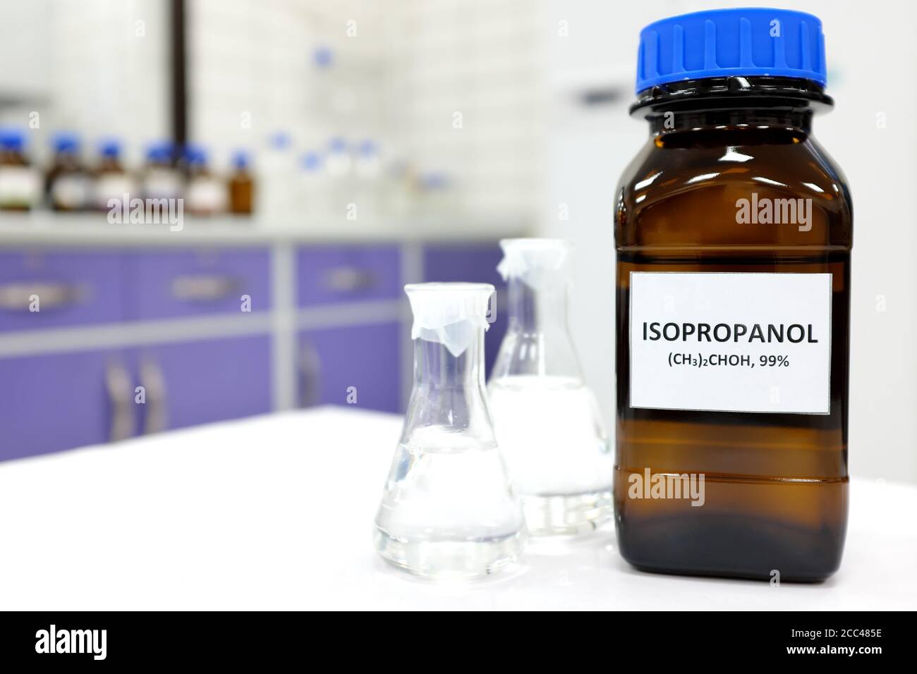 Messa a fuoco selettiva di flacone in vetro ambrato marrone isopropanolo all'interno di un laboratorio. Sfondo sfocato con spazio di copia. Foto Stock
