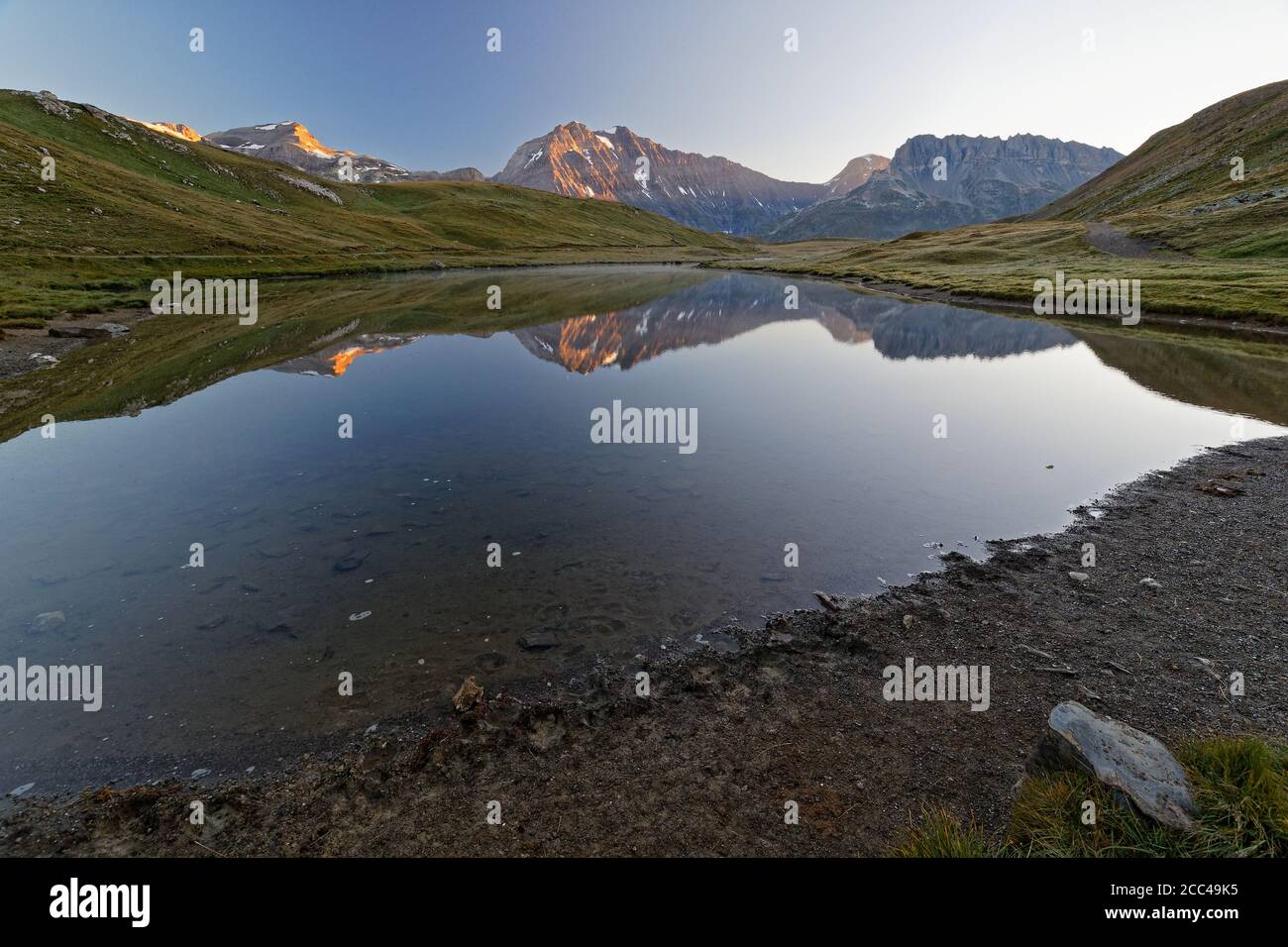 Refelctions su un lago di montagna all'alba Foto Stock