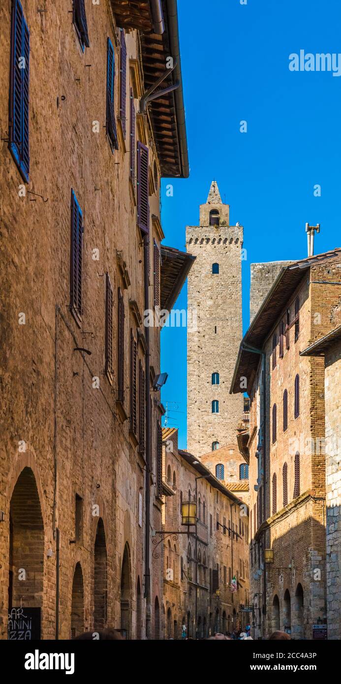 Pittoresco ritratto della via principale Via San Giovanni piena di negozi, e la torre più alta Torre grossa sullo sfondo della famosa... Foto Stock