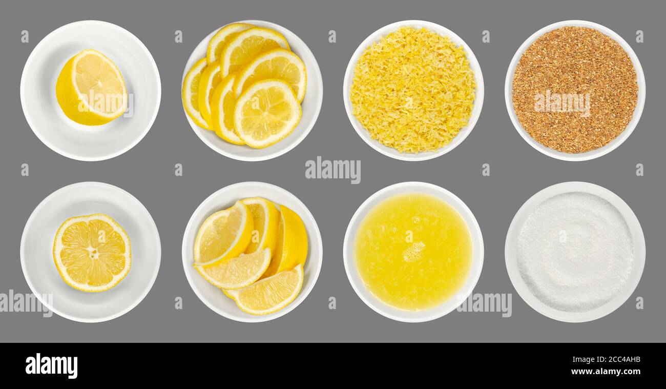 Limoni freschi e lavorati in ciotole di vetro bianco, di colore grigio. Metà del limone, spicchi, fette, scorza di limone grattugiata e secca, succo e acido citrico. Foto Stock