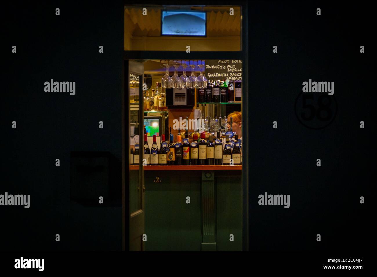 un bar o un pub girato attraverso la porta di notte al bar vi sono vari alcolici e vini Foto Stock