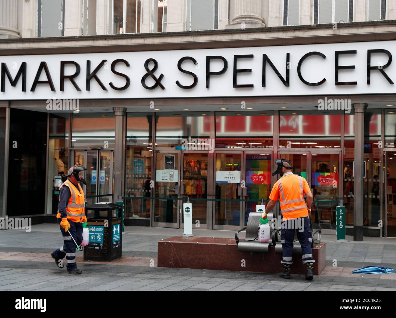 Leicester, Leicestershire, Regno Unito. 18 agosto 2020. I pulitori disinfettano i mobili di strada all'esterno di un negozio Marks and Spencer. Marks & Spencer sta tagliando 7,000 posti di lavoro in tutti i suoi negozi dichiarando che la pandemia di Òthe coronavirus aveva chiarito che c'era stato un cambiamento materiale in tradeÓ. Credit Darren Staples/Alamy Live News. Foto Stock