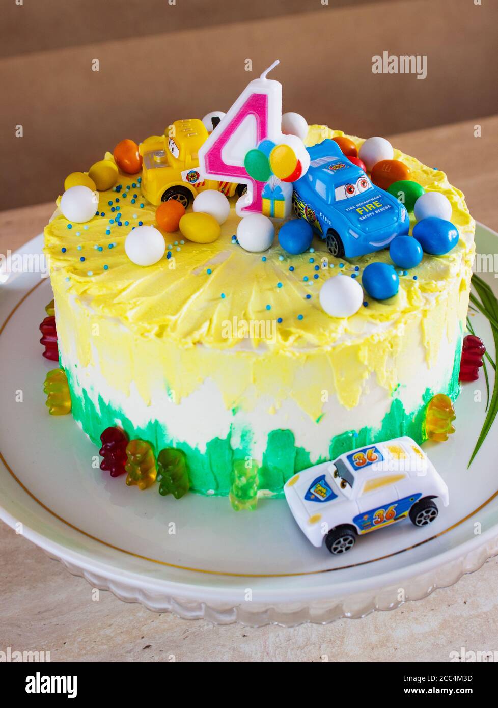 Torta di compleanno fondente colorata per bambini decorata con piccole auto Foto Stock