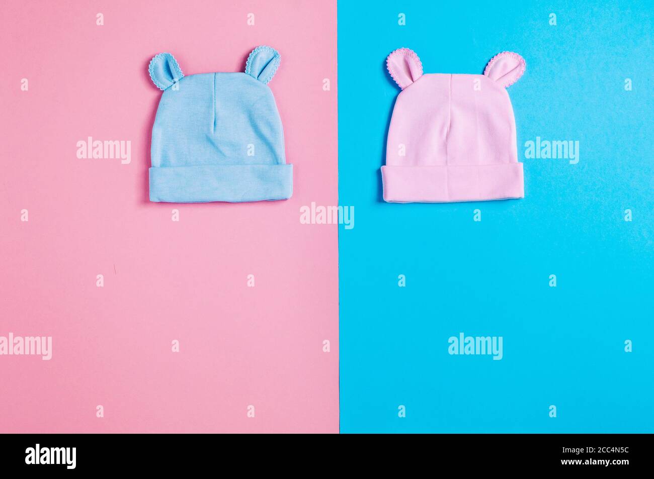 Berretti con orecchie su sfondo rosa e blu con spazio di copia Foto Stock