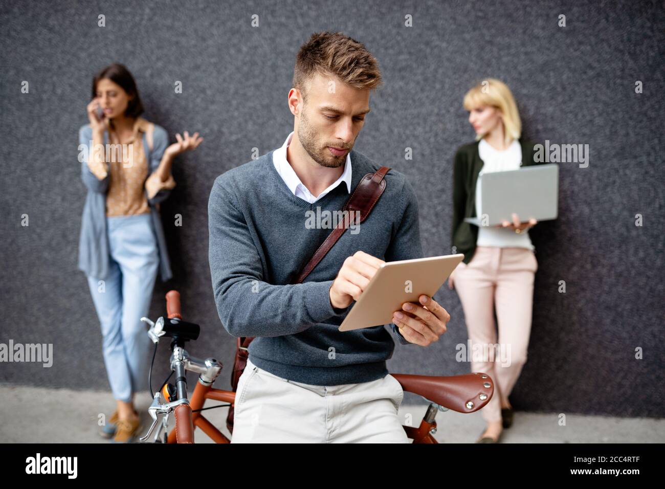 Gruppo di persone aziendali che utilizzano dispositivi elettronici all'aperto Foto Stock