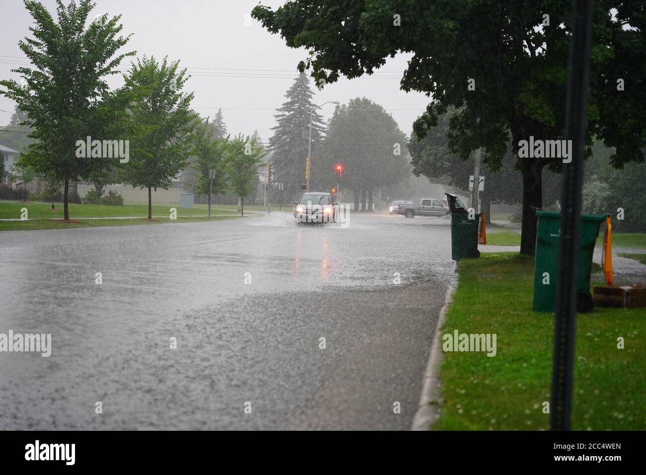 I cittadini di Fond du Lac guidano attraverso le strade allagate nei loro veicoli dall'enorme gocciolamento di pioggia durante il pomeriggio nel luglio 2020. Foto Stock