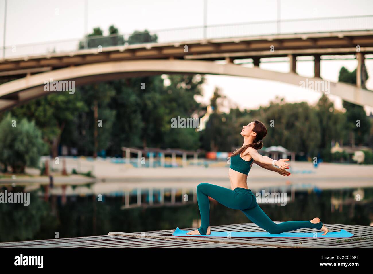 Sport donna fare yoga su piattaforma di legno Foto Stock